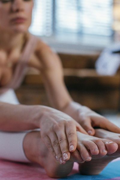 Close-up of a person's feet on a yoga mat during a stretch.